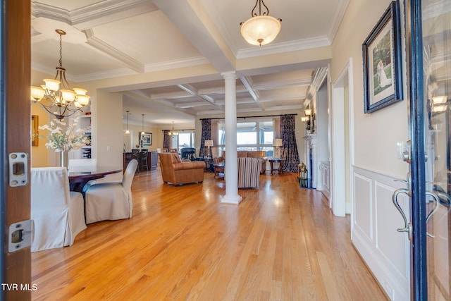 entrance foyer with ornate columns, ornamental molding, coffered ceiling, beam ceiling, and a notable chandelier