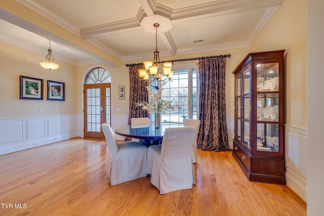 dining space with beam ceiling, coffered ceiling, light hardwood / wood-style floors, a chandelier, and ornamental molding