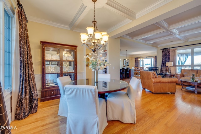 dining area with beamed ceiling, ornamental molding, and a chandelier