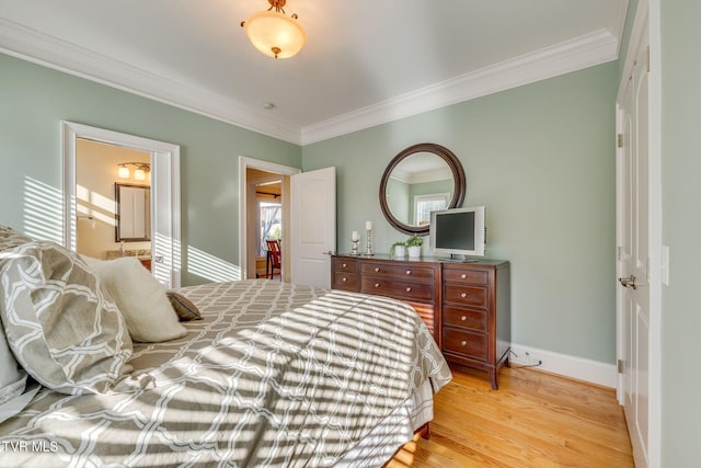 bedroom with light hardwood / wood-style floors, ensuite bath, multiple windows, and crown molding