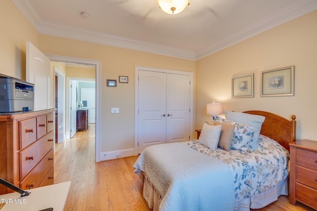 bedroom featuring light wood-type flooring, a closet, and crown molding