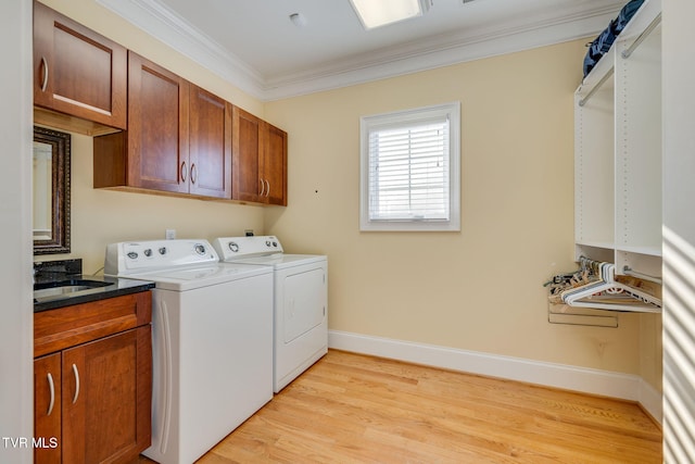 laundry room with cabinets, sink, washing machine and dryer, light wood-type flooring, and ornamental molding