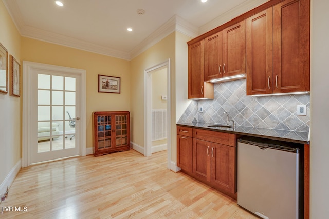 kitchen with sink, tasteful backsplash, crown molding, dishwashing machine, and light wood-type flooring