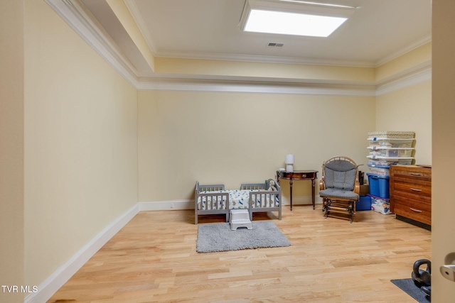 living area with light hardwood / wood-style flooring and ornamental molding