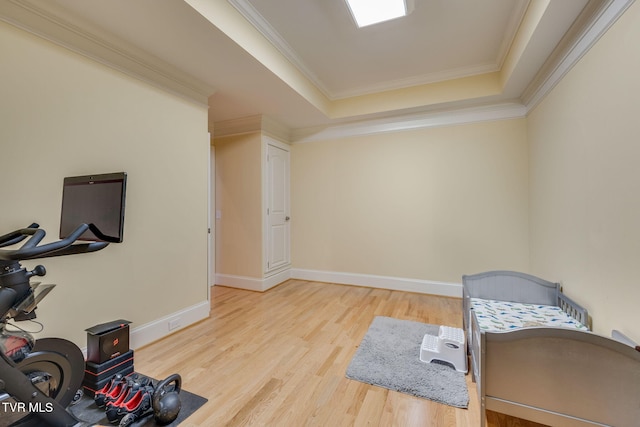 living area with hardwood / wood-style floors, a raised ceiling, and crown molding