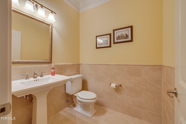 bathroom featuring tile patterned floors, crown molding, tile walls, and toilet