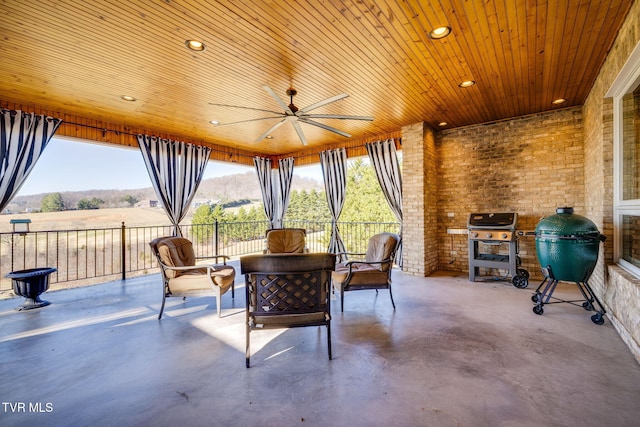 view of patio with ceiling fan, area for grilling, and a mountain view