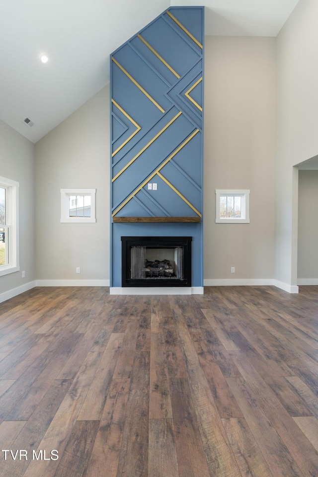 unfurnished living room featuring hardwood / wood-style flooring and high vaulted ceiling