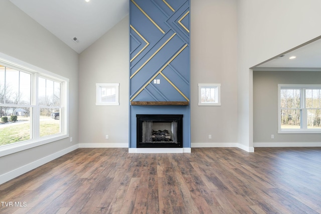 unfurnished living room with a large fireplace, dark hardwood / wood-style floors, and high vaulted ceiling