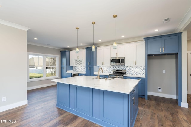 kitchen with light stone countertops, stainless steel appliances, an island with sink, sink, and hanging light fixtures