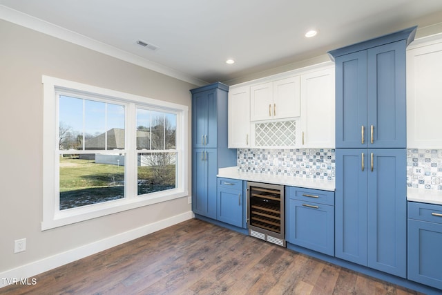 bar with white cabinets, beverage cooler, backsplash, dark hardwood / wood-style floors, and ornamental molding