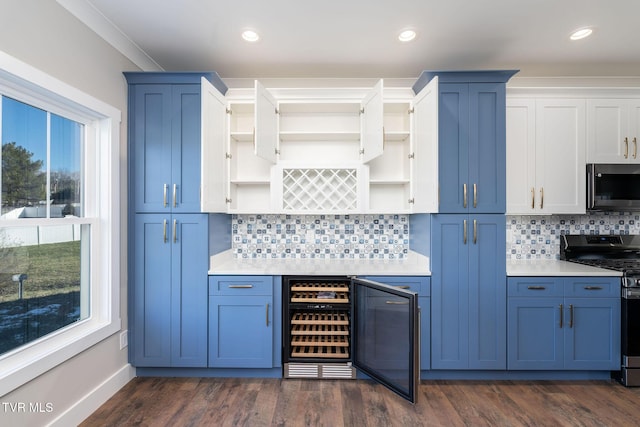 kitchen featuring dark wood-type flooring, beverage cooler, and appliances with stainless steel finishes