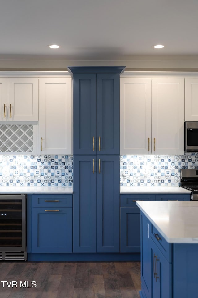 kitchen with wine cooler, stove, blue cabinetry, and tasteful backsplash