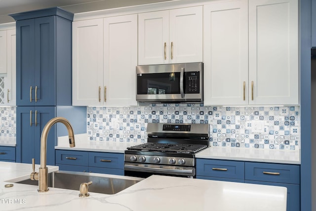 kitchen with light stone counters, sink, white cabinetry, and appliances with stainless steel finishes