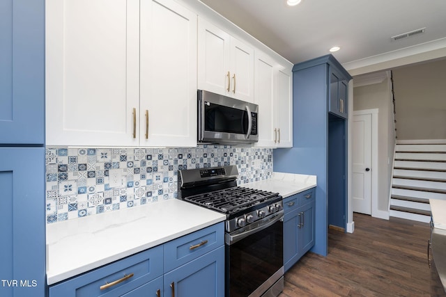 kitchen with stainless steel appliances, blue cabinets, backsplash, and light stone counters