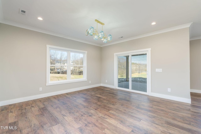 empty room with a wealth of natural light, a notable chandelier, ornamental molding, and hardwood / wood-style floors