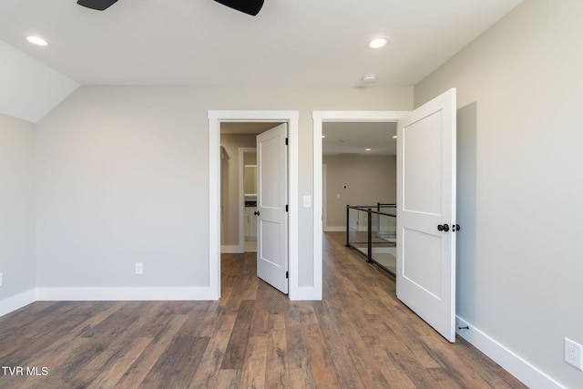 unfurnished bedroom featuring vaulted ceiling and dark hardwood / wood-style floors