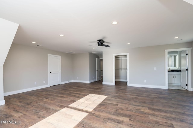 unfurnished living room featuring ceiling fan and dark hardwood / wood-style flooring