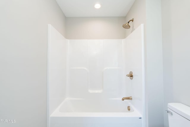 bathroom featuring tub / shower combination and toilet