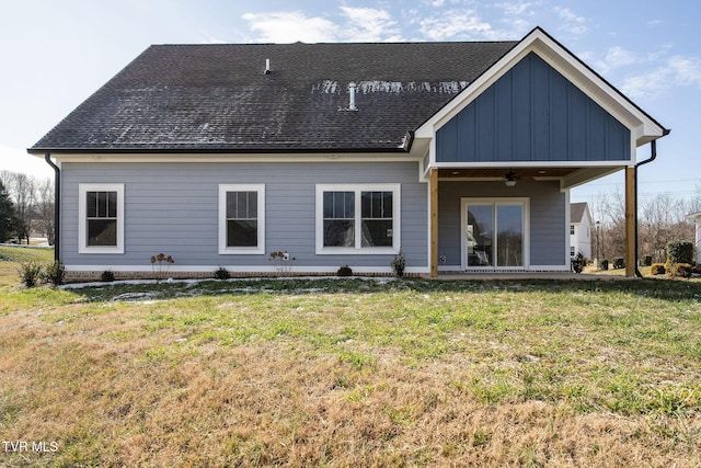 rear view of property featuring ceiling fan and a lawn