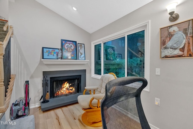 living area with hardwood / wood-style floors and lofted ceiling