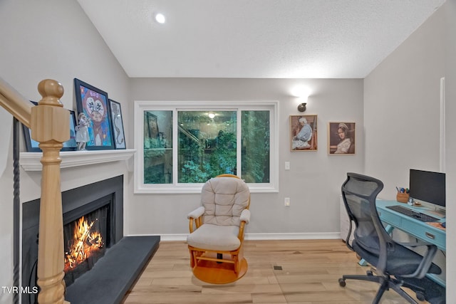 office area with hardwood / wood-style floors, a textured ceiling, and vaulted ceiling