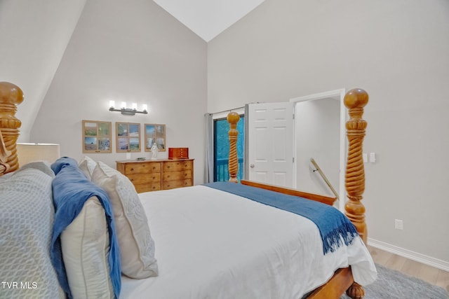 bedroom with hardwood / wood-style floors and high vaulted ceiling