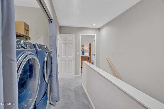 laundry area featuring washing machine and dryer and light colored carpet