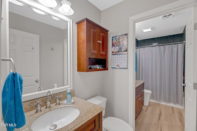 bathroom with vanity, hardwood / wood-style flooring, and toilet