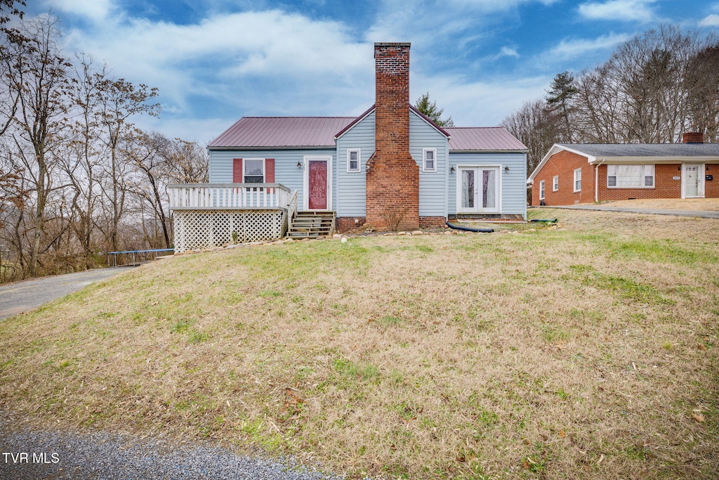 rear view of house featuring french doors, a yard, a trampoline, and a wooden deck