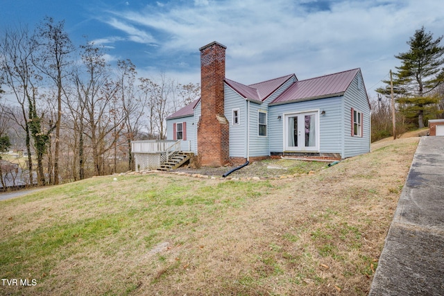 rear view of property with a lawn, a wooden deck, and french doors