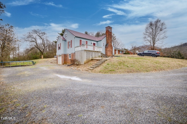 view of side of home featuring a yard, a trampoline, a garage, and a wooden deck