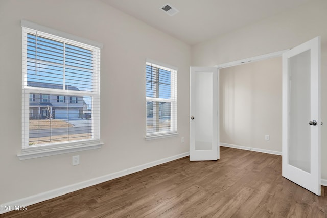 unfurnished bedroom with french doors and hardwood / wood-style flooring