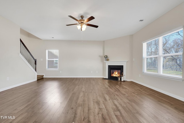 unfurnished living room with hardwood / wood-style flooring and ceiling fan