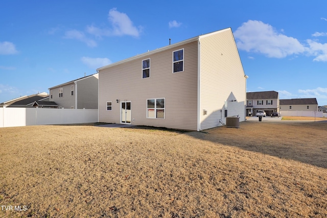 back of property with a lawn and cooling unit