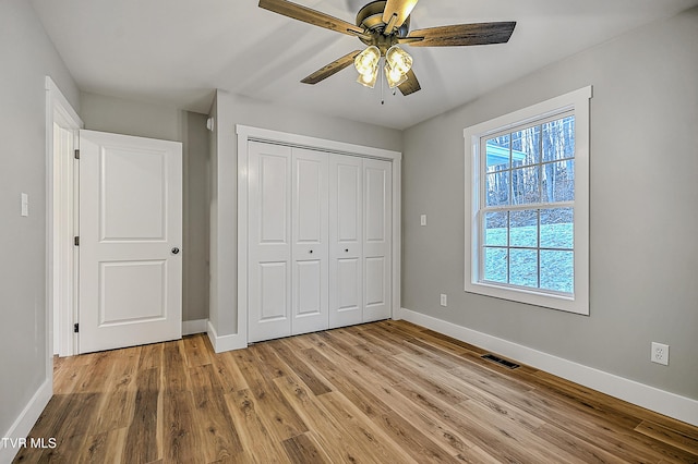 unfurnished bedroom featuring ceiling fan, light hardwood / wood-style flooring, and a closet