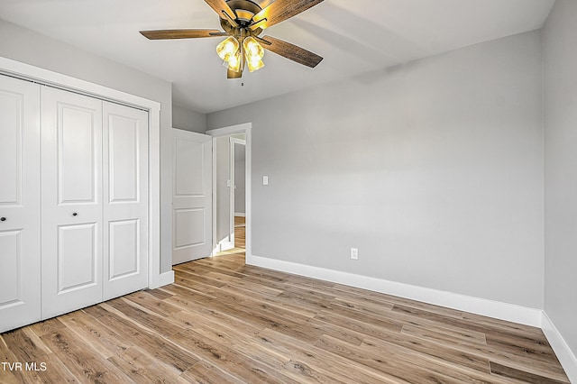 unfurnished bedroom with ceiling fan, a closet, and light wood-type flooring