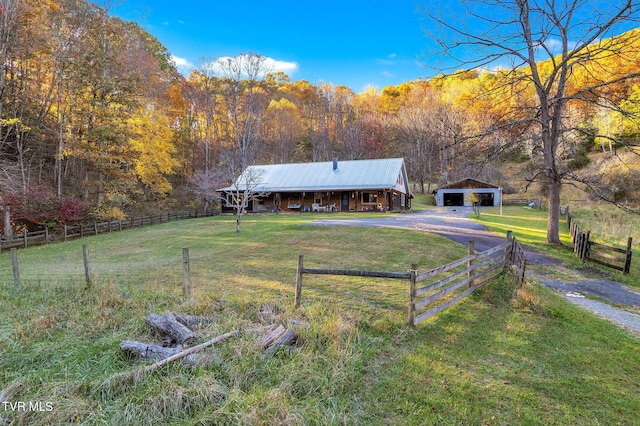 view of front of property with a rural view, a garage, an outdoor structure, and a front yard