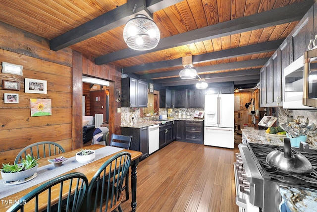 kitchen featuring white refrigerator with ice dispenser, backsplash, high end stove, dishwashing machine, and beam ceiling