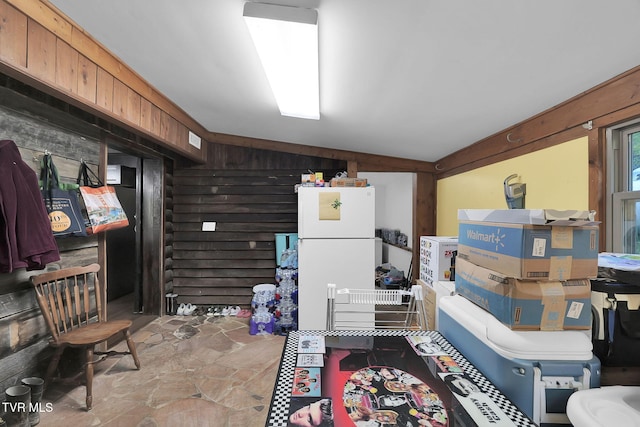 miscellaneous room featuring wooden walls and vaulted ceiling