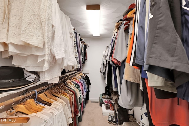 walk in closet featuring light carpet