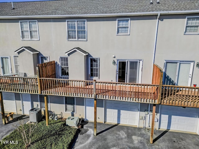 back of house with central AC unit and a garage