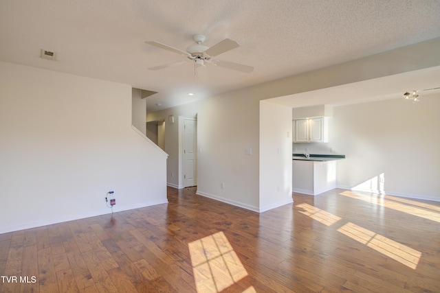 unfurnished room featuring a textured ceiling, hardwood / wood-style flooring, and ceiling fan