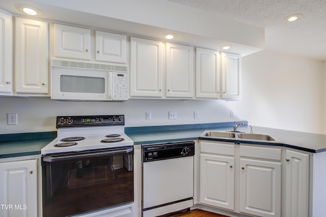 kitchen featuring white appliances, white cabinetry, and sink