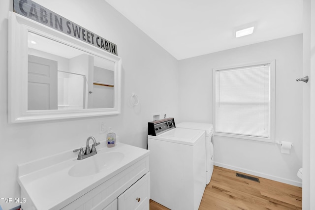 bathroom with separate washer and dryer, hardwood / wood-style flooring, and vanity