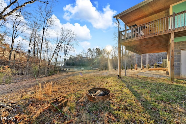 view of yard with a deck and a fire pit