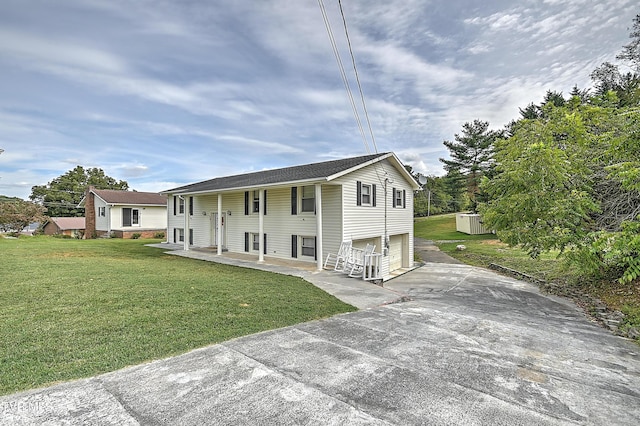 bi-level home featuring a front lawn, covered porch, and a garage