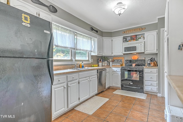 kitchen with crown molding, sink, black appliances, white cabinetry, and light tile patterned flooring