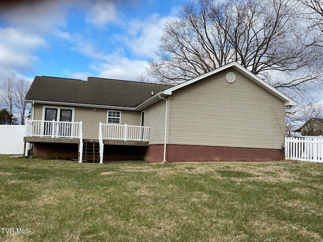 rear view of house featuring a deck and a yard