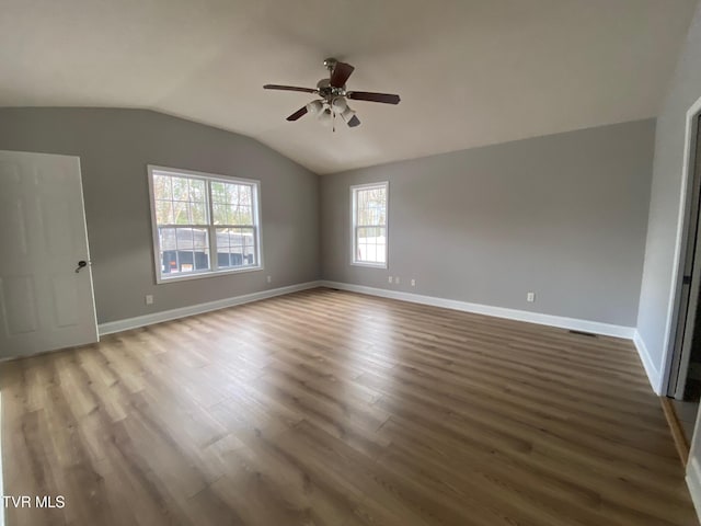 spare room with ceiling fan, lofted ceiling, and dark wood-type flooring